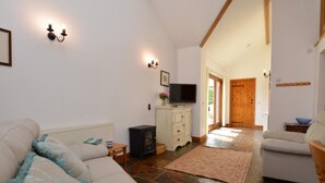 Una sala acogedora con un sofá, un televisor, un aparador y una chimenea.