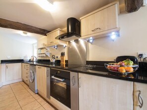 A modern kitchen with stainless steel appliances, wooden cabinets, and a fruit bowl on the counter. - 3 Bed in Baslow (oc-pk908) (Baslow)