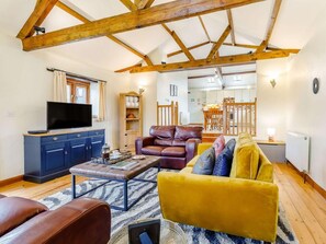 A living room with a TV, leather sofa, yellow couch, and a wooden ceiling. - 2 Bed in Holsworthy (oc-gfoxg) (Holsworthy Hamlets)