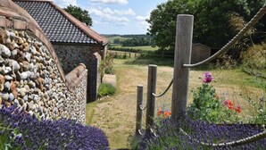 A stone wall, a wooden gate, and a rural landscape with a clear sky. - 5 Bed in Wiveton (oc-kt021) (Wiveton)