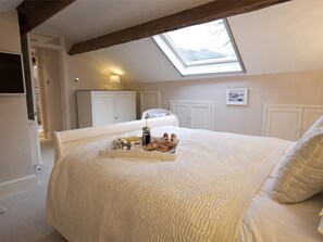 A bedroom with a skylight, a bed with a tray of breakfast items, and white furniture. - 1 Bed in Harrogate (oc-g0063) (Hartwith cum Winsley)