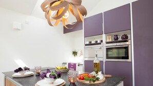A modern kitchen with a central island, built-in appliances, and a pendant light. - 1 Bed in Thornton Watlass (oc-g0089) (Thornton Watlass)