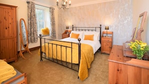 A bedroom with a four-poster bed, wooden furniture, a mirror, and a chandelier. - 3 Bed in Cleator (oc-sz392) (Ennerdale Bridge)