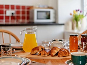 A breakfast table with croissants, a pitcher of orange juice, and various glassware. - 2 Bed in Kirkby Stephen (oc-sz265) (Newbiggin-on-Lune)