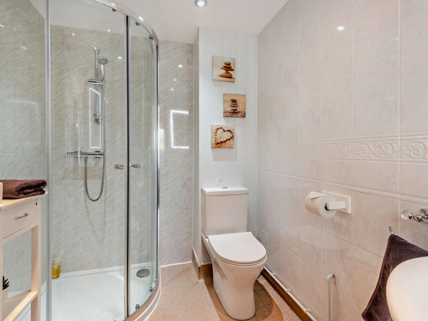 Ein modernes Badezimmer mit einer Duschkabine, einer Toilette und einem Waschbecken.
