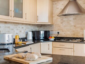 A kitchen with a microwave, stove, and various appliances. - 2 Bed in Tenby (oc-fb115) (Tenby)