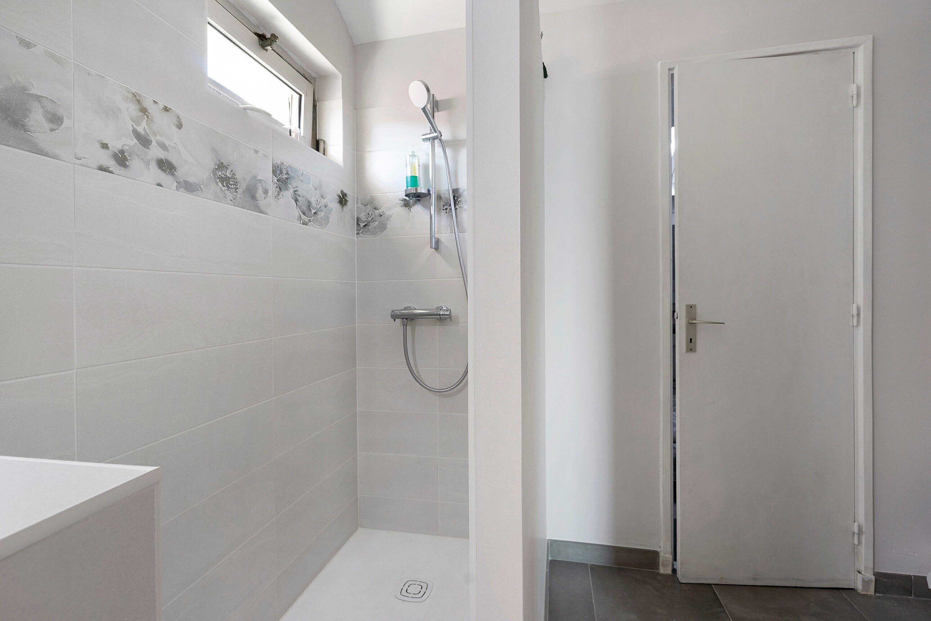 A bathroom with a shower, a toilet, and a sink.