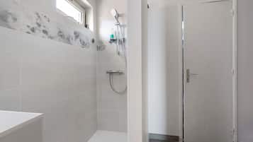 A bathroom with a shower, a toilet, and a sink.