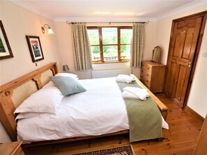 A bedroom with a wooden bed, a nightstand, a dresser, and a window with curtains. - 1 Bed in Liskeard (oc-nutha) (Broadoak)