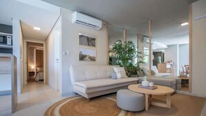 Ein modernes Wohnzimmer mit einem weißen Sofa, einem runden Couchtisch und einem großen Spiegel.