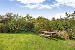 A picnic table in a grassy area with dense foliage in the background. - 2 Bed in Kingsbridge (oc-fern3) (Kellaton)
