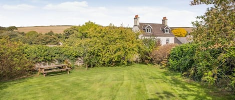 A house with a well-maintained lawn and a wooden bench.