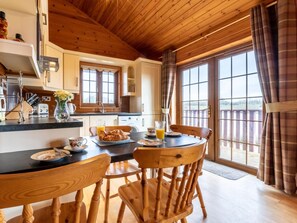 A wooden interior with a dining table set for breakfast, including croissants and orange juice.