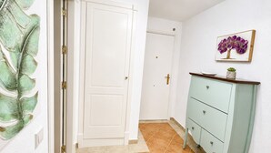 A hallway with a white door, a light green cabinet, and a framed picture on the wall. - Las Dunas, T1 (Punta del Moral)
