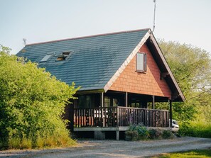 Una casa de dues plantes amb teulada inclinada, un balcó i una antena parabòlica.
