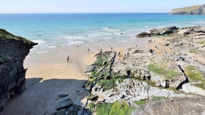 A rocky beach with clear blue water, a sandy area, and cliffs in the background. - 2 Bed in Launceston (oc-congs) (Congdon's Shop)