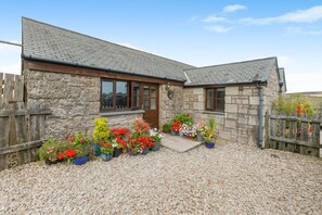 A stone house with a gravel driveway and a wooden fence. - 1 Bed in Penzance (oc-henst) (Saint Buryan)