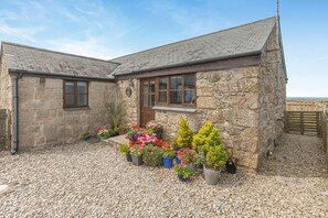 A stone house with a gravel driveway and a variety of potted plants in front. - 1 Bed in Penzance (oc-ducks) (Saint Buryan)