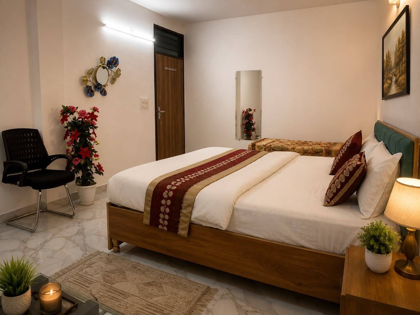 Ein Schlafzimmer mit einem Bett, einem Sessel, einem Blumentopf, einem Spiegel und einem Wandbild.