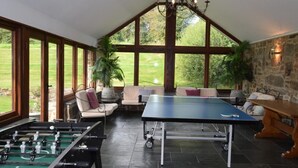 Ein Raum mit Kicker, Tischtennis und einer Sitzgelegenheit mit Blick ins Freie.