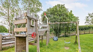 Une structure de jeu en bois avec une balançoire et un toboggan.
