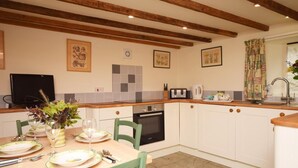 A kitchen with white cabinets, a wooden countertop, a microwave, a toaster, and a sink. - 2 Bed in Umberleigh (oc-lcobb) (Chittlehampton)