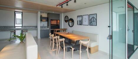 Una cocina moderna con comedor, una gran mesa de madera y sillas.