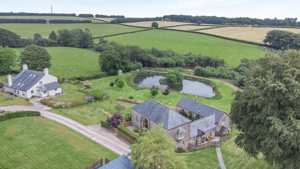 A rural property with a pond, stone buildings, and expansive green fields. - 1 Bed in Taunton (oc-oldli) (Wiveliscombe)
