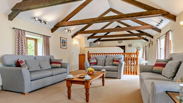 A spacious living room with two grey sofas, a wooden coffee table, and exposed wooden beams on the ceiling. - 2 Bed in Camborne (oc-oldmm) (Camborne)