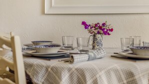 A dining table with a checkered tablecloth, a vase with purple flowers, and a framed picture above the table. - 2 Bed in Barnstaple (oc-oldma) (Landkey)