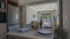 A modern kitchen with a dining area, a built-in oven, and a large window.
