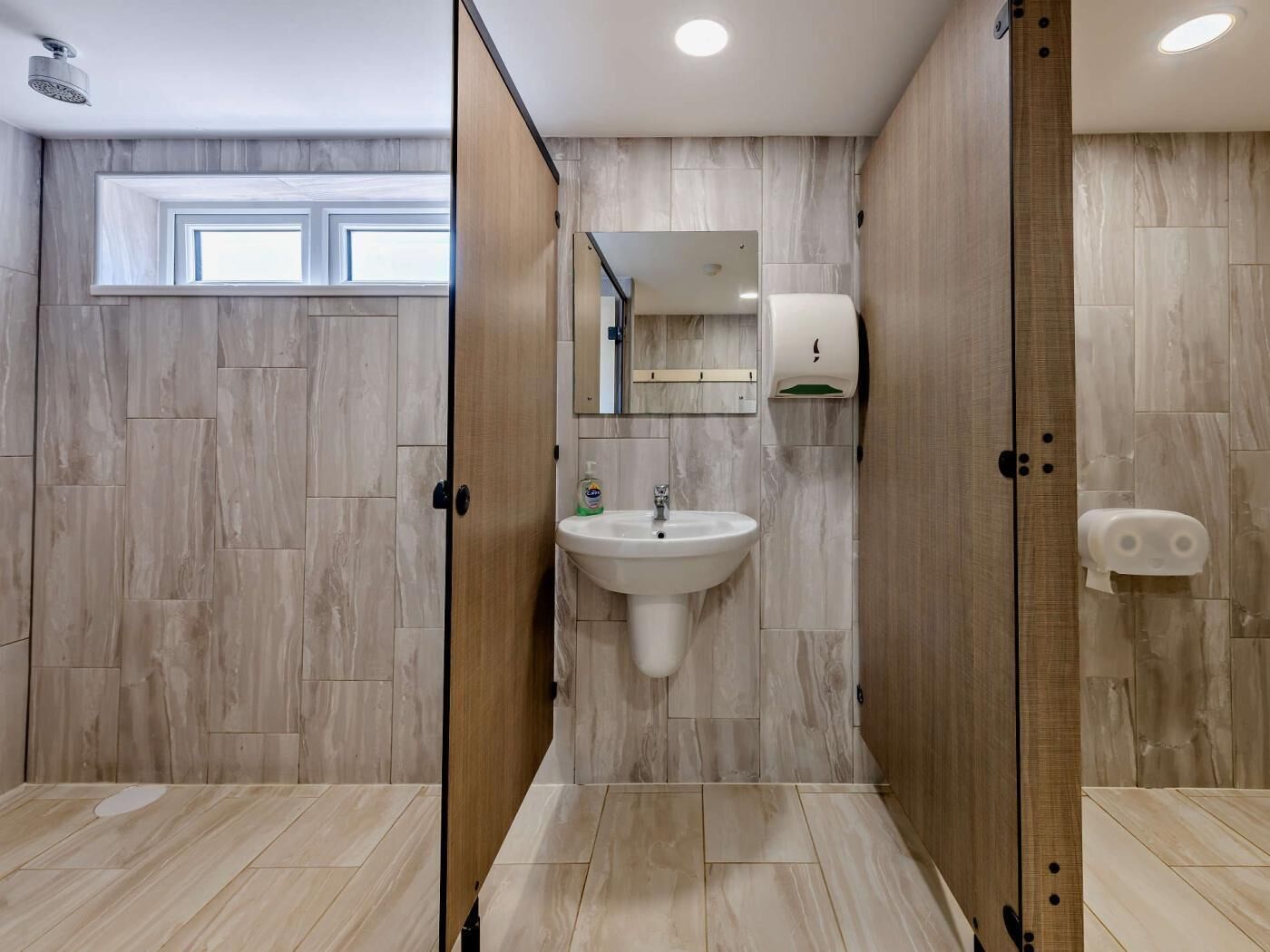 Une salle de bain moderne avec un lavabo, un miroir et un sèche-mains.