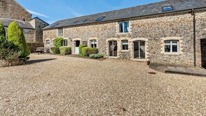 A stone building with a gravel driveway and a small garden area. - 6 Bed in Bideford (oc-thorn) (Buckland Brewer)