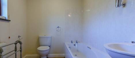 A bathroom with a toilet, bathtub, and sink.