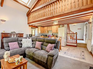 A cozy living room with a sectional sofa, a wooden ceiling, and a kitchen in the background. - 2 Bed in Looe (oc-fosea) (Lansallos)