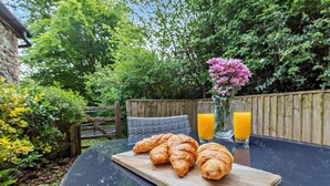 Une table avec des croissants, du jus de fruits et des fleurs.