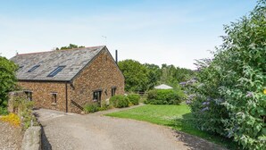 A stone farmhouse with a gravel driveway and a garden. - 3 Bed in Bude (oc-woott) (Poundstock)