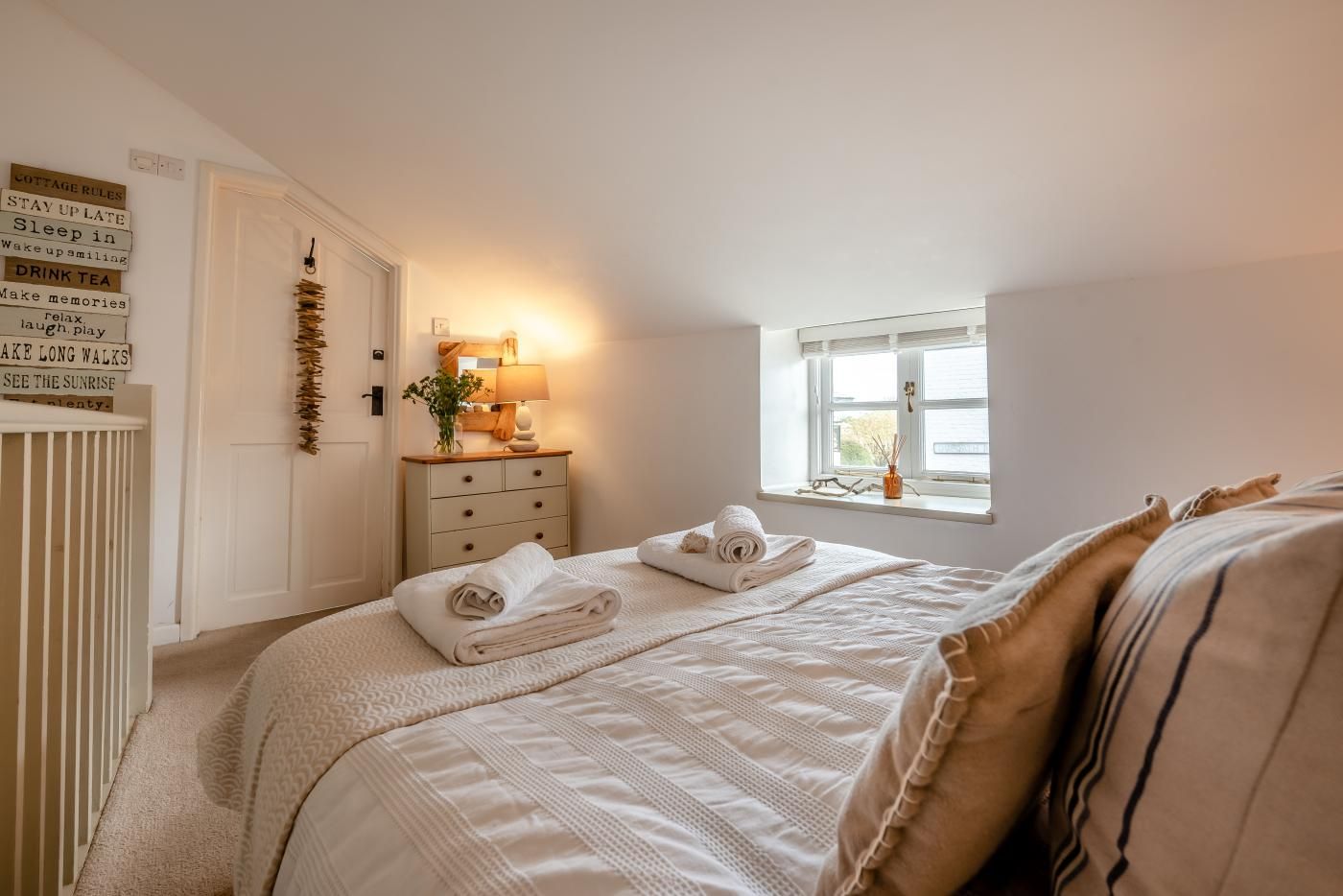 A bedroom with a bed, a dresser, a window, and a wall with text.