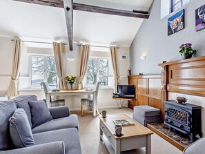 A modern living room with a sofa, a coffee table, a fireplace, and a desk with a computer. - 1 Bed in Dulverton (oc-lbard) (Dulverton)