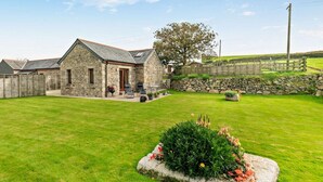 A stone house with a patio, a lawn, and a stone wall. - 1 Bed in Helston (oc-boder) (Wendron)