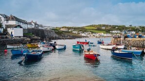 A harbor with boats docked, a stone wall, and buildings in the background. - 1 Bed in Helston (oc-boder) (Wendron)