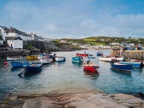 A harbor with boats docked, a stone wall, and buildings in the background. - 1 Bed in Helston (oc-boder) (Wendron)
