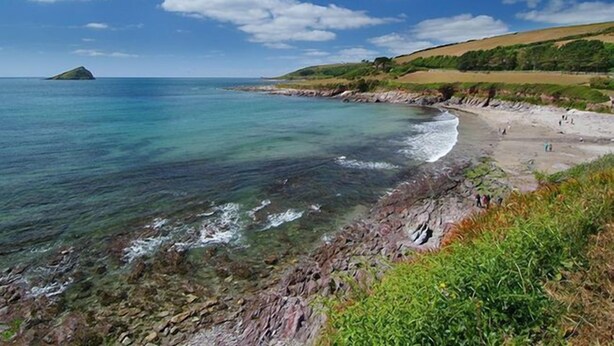 A coastal beach with clear water, rocky shore, and a small island in the distance. - 3 Bed in Plymouth (oc-combv) (Wembury)