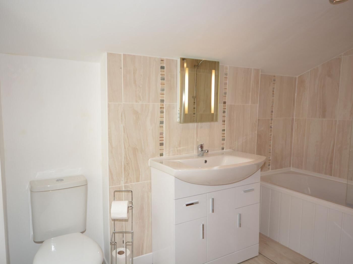 A bathroom with a toilet, sink, and bathtub.