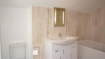 A bathroom with a toilet, sink, and bathtub.