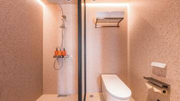 Un baño moderno con cabina de ducha de vidrio, inodoro y barra para toallas.