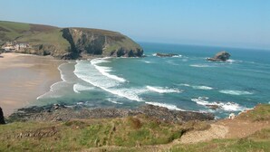 Un paisaje costero con playa, costa rocosa y un acantilado.