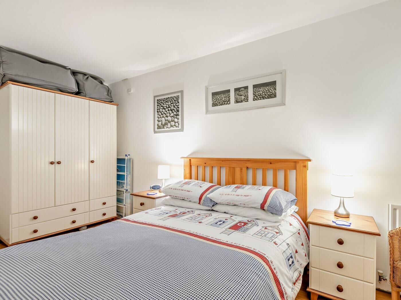 Ein Schlafzimmer mit einem Bett, einem Kleiderschrank, einem Nachttisch und einer Lampe.