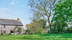 A stone house with a grassy yard and a large tree. - 2 Bed in Wadebridge (oc-jobes) (Chapel Amble)