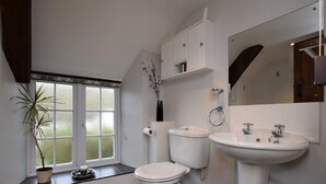 A bathroom with a toilet, sink, and window. - 3 Bed in Chard (oc-barra) (Winsham)